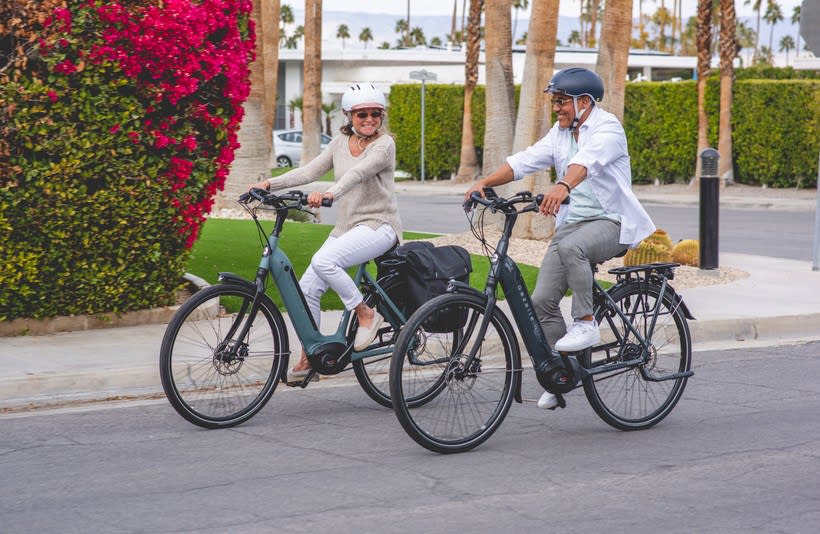 Image of middle aged adults riding ebikes on a California Boulevard