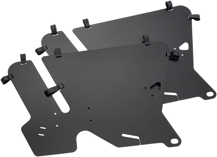 The Benno Boost Wheel Guard Set by Benno features two black, rectangular metal plates with rounded corners, multiple cutouts, and black fabric loops along the edges. Ideal for cargo protection, the plates are shown slightly overlapping on a white background.