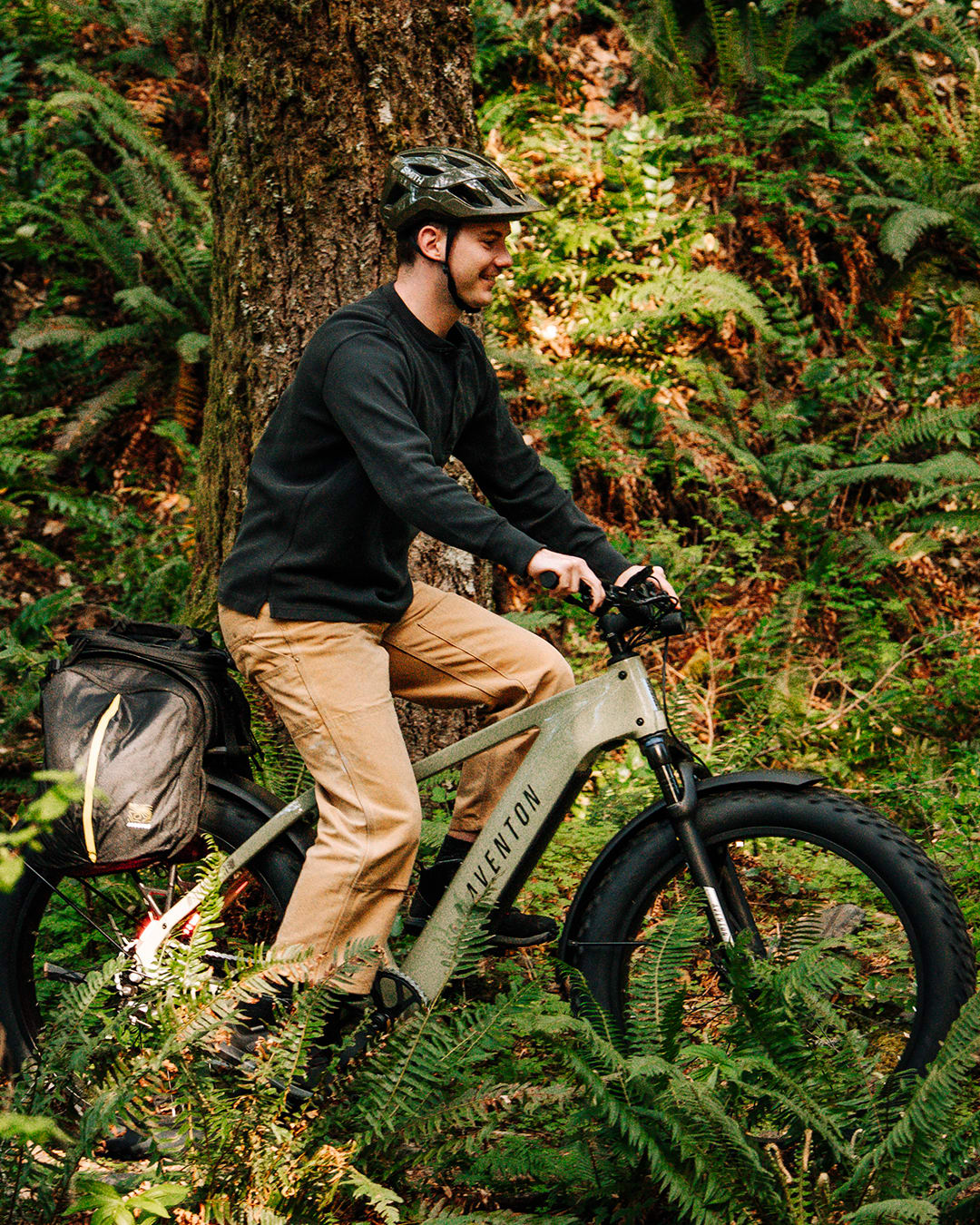 Man riding an Aventure 3 matcha fat tire electric bike in a forest setting available at CyclErie in Erie, CO.