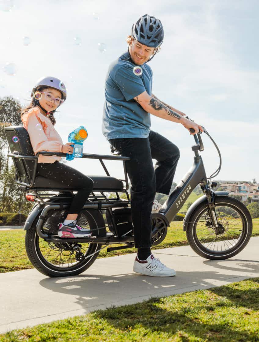 Dad and child riding an Aventon Abound LR on a sunny day.