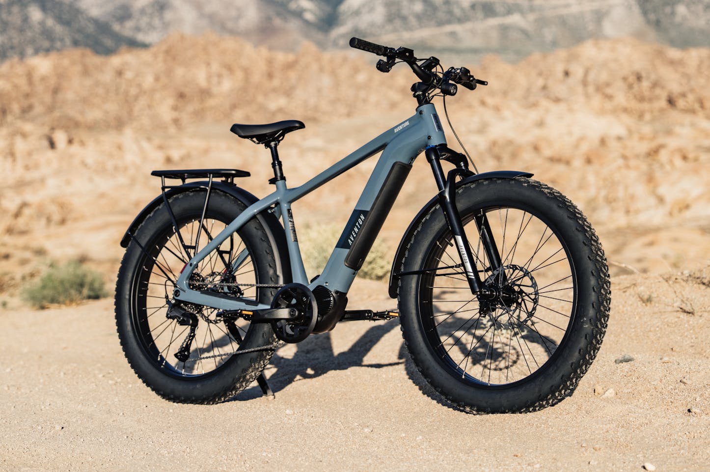 Aventon Aventure M MID-drive ebike available at CyclErie in Erie, CO. Fat-tire bicycle on a desert landscape.
