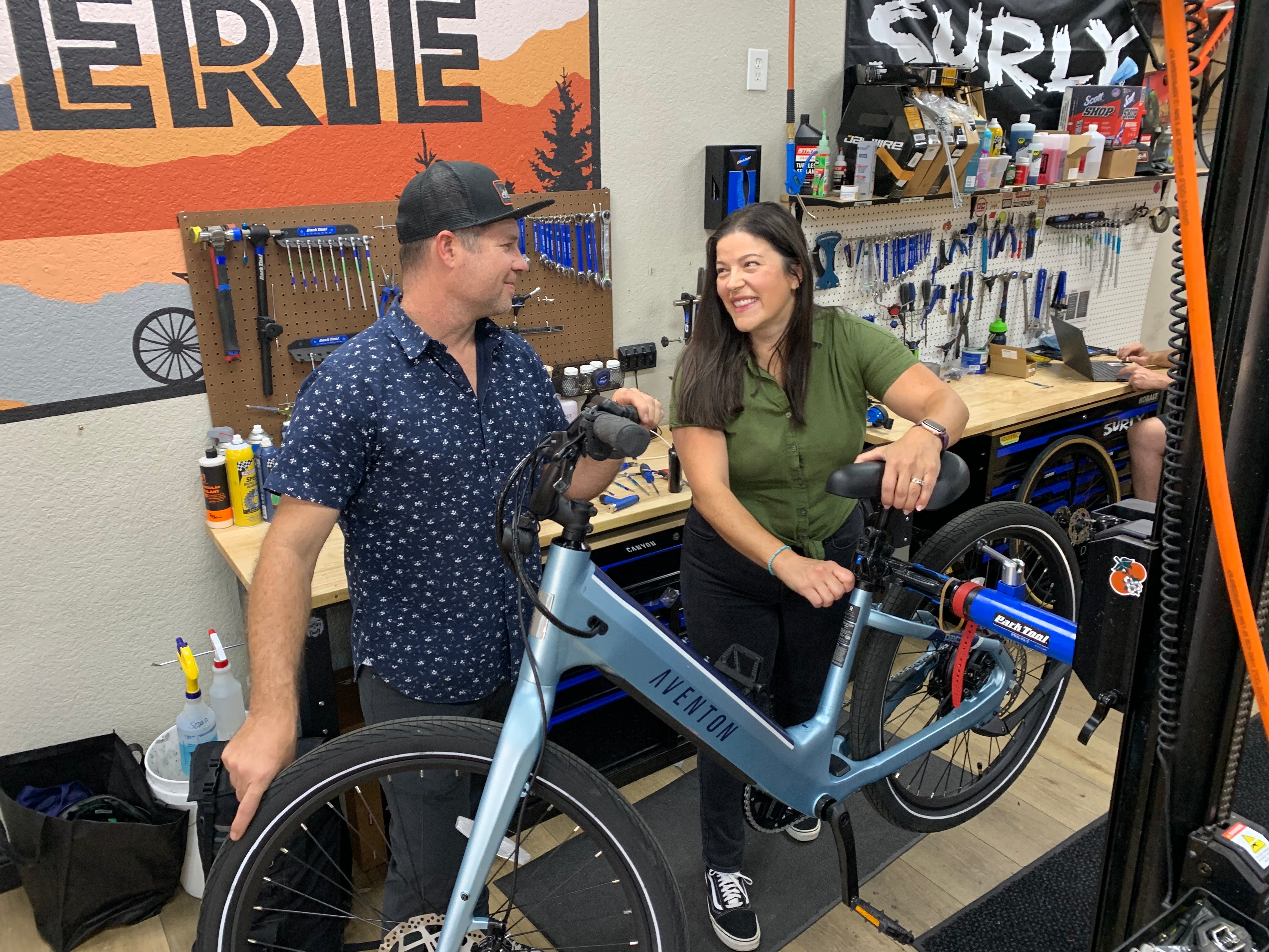 Jenny and Dan Johnson Founders of CyclErie Bike Shop in Erie Colorado with a Blue Aventon Pace 4 eBike