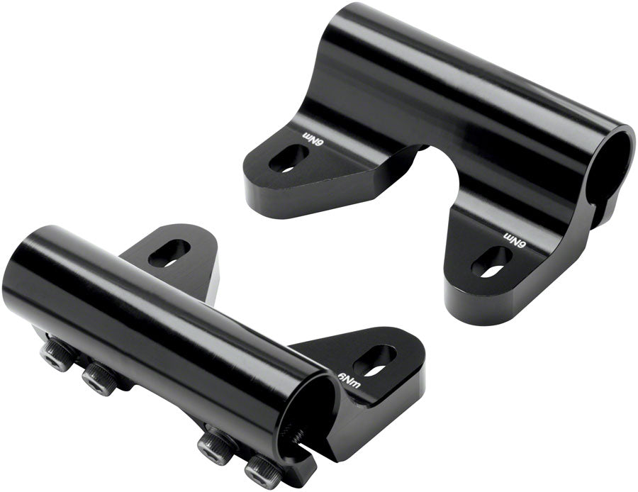 The Benno Rail Clamp Plus - Set Black by Benno features two black metal clamps with cylindrical tubes and bolt fasteners marked LIND and 6NM, designed for Utility Rack or Boost E 2020, shown on a white background.