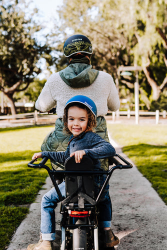 Image of a small child riding on the back of an electric cargo bicycle