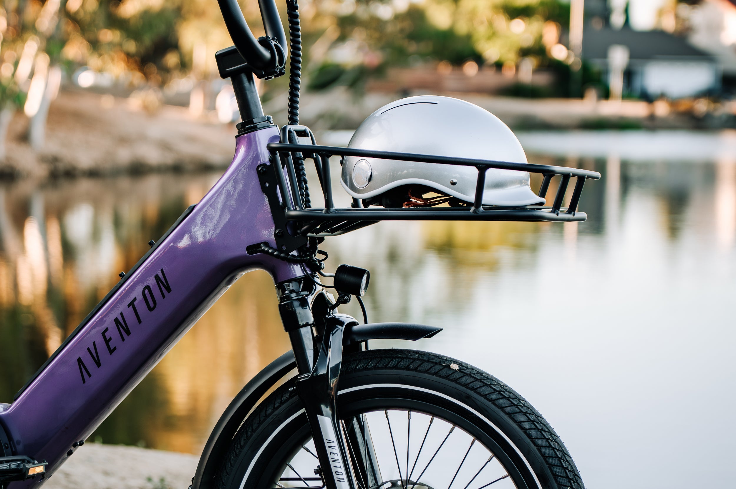Aventon Abound SR in haze purple color with a front rack set installed carrying a helmet.