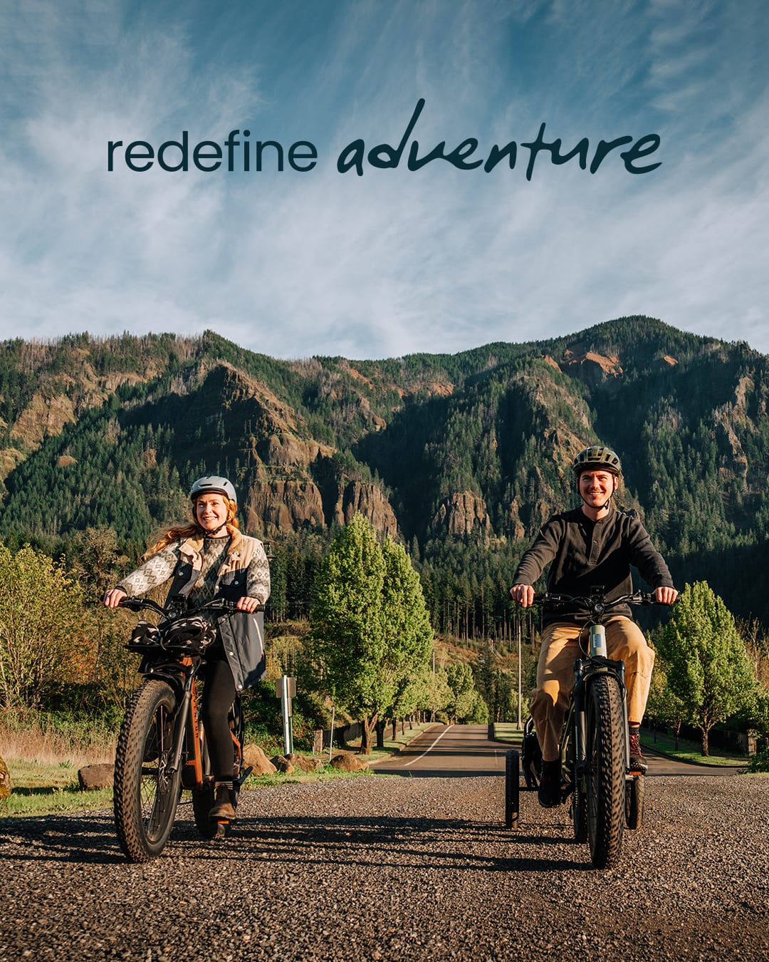 Two people riding Aventure 3 ebikes on a road with mountains available at CyclErie in Erie, CO.