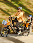 Mom and child riding an Aventon Abound LR on a beautiful day. The child is in a Thule Yepp seat.