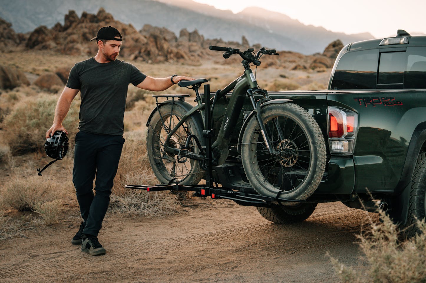 Man with a Aventon Aventure M emtb on a vehicle rack attached to a truck in a desert setting