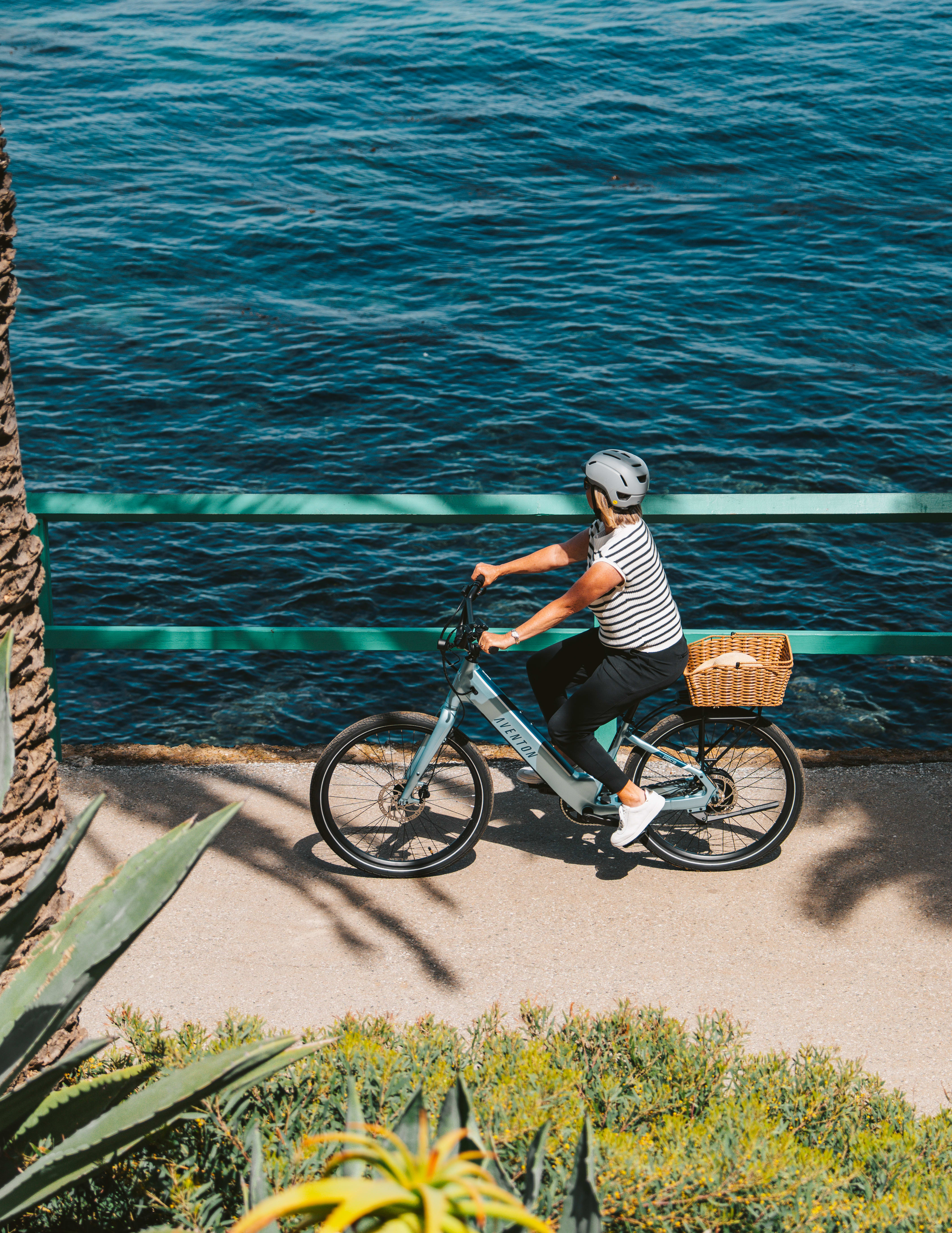 Elegant light blue Aventon Pace 4 cruiser e-bike parked on a modern city street, showcasing its refined step-through geometry, smooth torque-sensor assist, smart display, and sophisticated color accents that blend lightweight design with high-end comfort and style—perfect for relaxed Denver neighborhood cruises.