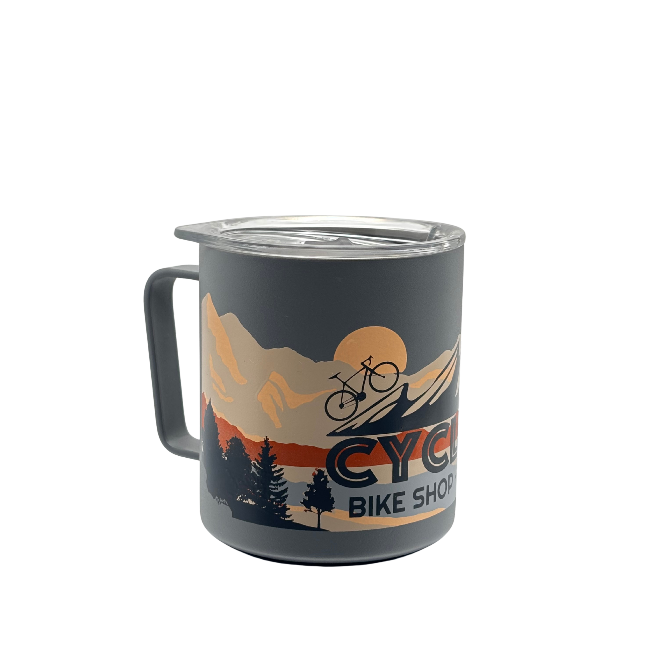Matte grey Miir 12oz camp cup with vibrant full-color CyclErie eBikes rainbow logo and “Erie Colorado” text, press-fit slide lid on, photographed on a rocky Colorado trail with pine trees in the background.