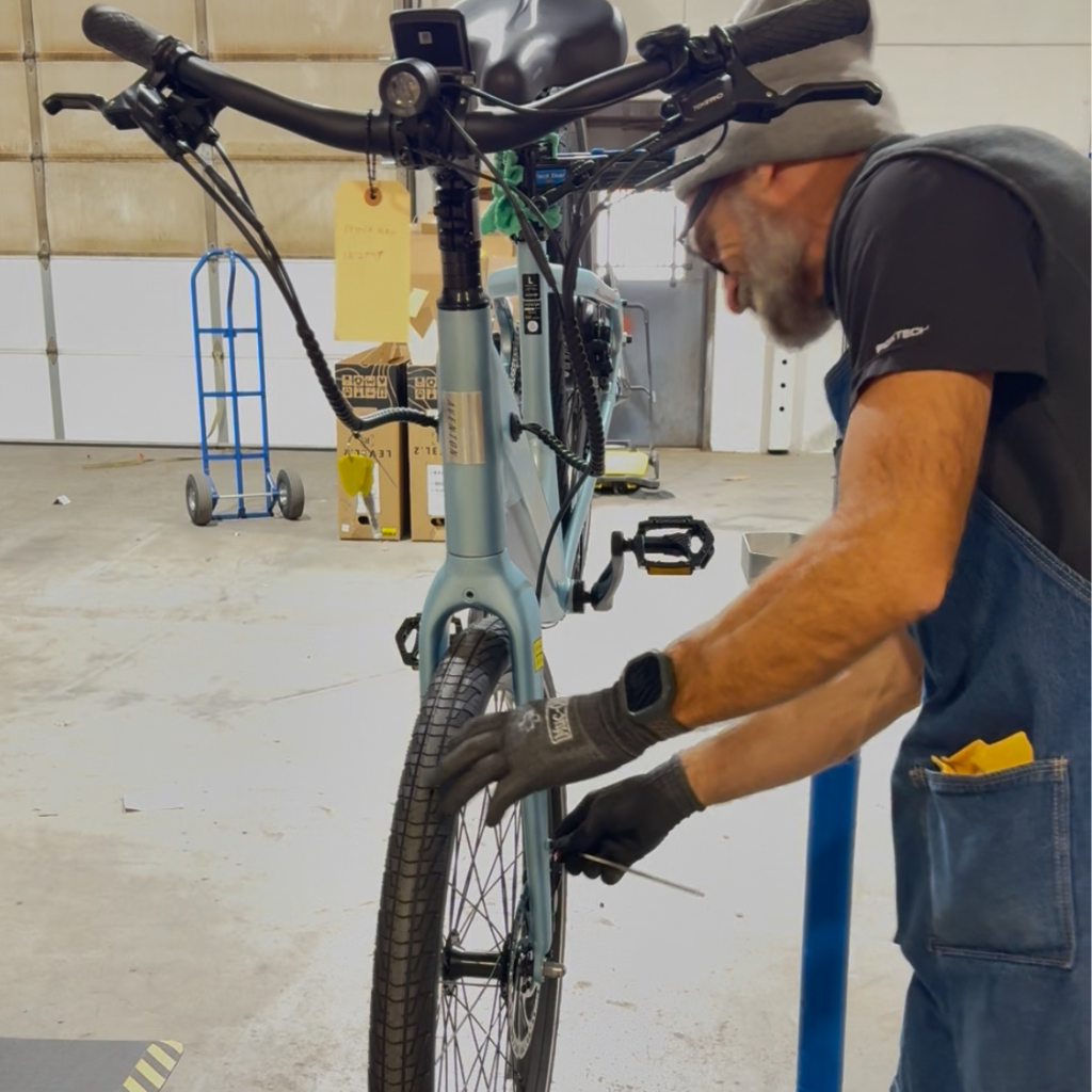 Mechanic at CyclErie Bike Shop in Erie Colorado Performing Quality Control Check on. an Aventon Pace 500.3 built by the build team at the CyclErie Service and Fulfillment Center